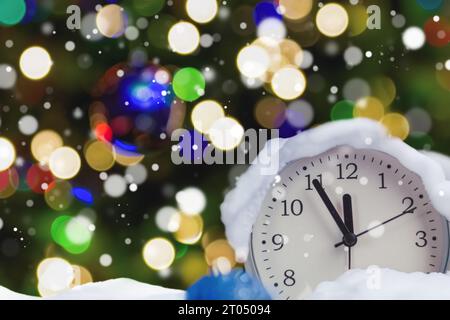 Der Wecker zeigt an, dass es in fünf Minuten zwölf Uhr ist, das neue Jahr. Fünf Minuten bis zwölf, Silvester. Nahaufnahme. Neujahr b Stockfoto