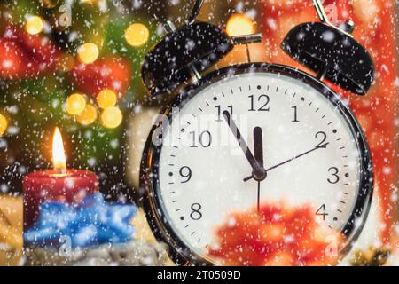 Der Wecker zeigt an, dass es in fünf Minuten zwölf Uhr ist, das neue Jahr. Fünf Minuten bis zwölf, Silvester. Nahaufnahme. Neujahr b Stockfoto