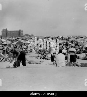 Badegäste am Rockaway Beach in Queens, New York. Dieses Foto stammt von einem nicht zugeschriebenen persönlichen Fotoalbum einer Kreuzfahrt nach New York vom 29. Juni bis 13. August 1956. Segeln von Liverpool an Bord des Cunard-Schiffes M.V. Britannic und Rückfahrt von New York nach Southampton an Bord des Cunard-Schiffes R.M.S. Queen Mary. Die durchschnittliche Größe der Originalfotos betrug 4 x 3 Zoll. Stockfoto