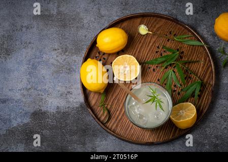 Erfrischender hausgemachter Zitronensaft mit Marihuana. Alkoholfreier Sommercocktail mit Zitrone, Cannabis und Eiswürfeln Stockfoto