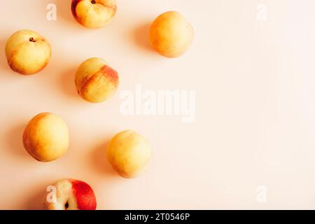 Reife frische Pfirsiche auf hellrosa Hintergrund. Draufsicht, flach, Kopierbereich. Stockfoto