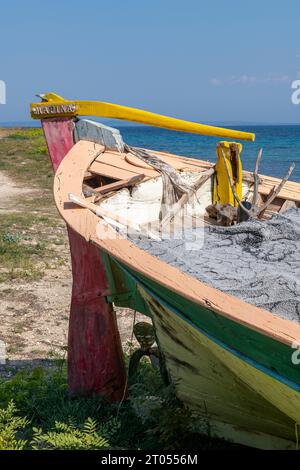 Altes griechisches traditionelles Fischerboot, das an der Küste der griechischen Insel zante oder zakynthos angespült wird. Schiffbrüchiges farbenfrohes Boot am griechischen Strand. Stockfoto