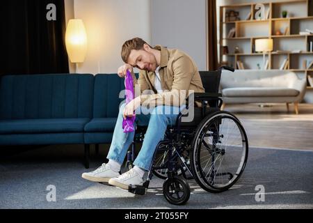 Junger behinderter Mann im Rollstuhl, der zu Hause Übungen mit Gummiband macht. Ein kaukasischer Behinderter, der im Wohnzimmer trainiert. Stockfoto