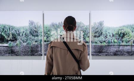 London, Großbritannien. Oktober 2023. Ein Besucher betrachtet Monica de Mirandas „Salzinsel“ (2022), eine Serie von 5 Bildern, die eine grüne Landschaft darstellen. „RE/SISTERS: A Lens on Gender and Ecology“ ist eine neue Ausstellung in der Barbican Art Gallery, die die Arbeiten von fast 50 Künstlern zusammenbringt und die Beziehung zwischen Gender und Ökologie durch Film, Fotografie und Installation untersucht. Die Ausstellung läuft bis zum 14. Januar 2024. Quelle: Imageplotter/Alamy Live News Stockfoto