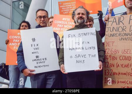 London, Großbritannien. Oktober 2023. Ärzte stehen mit Plakaten, die für verbesserte Personalbedingungen bei der britischen Ärztekammer (BMA) vor dem University College Hospital auffordern, da Berater des NHS (National Health Service) und junge Ärzte ihren gemeinsamen Streik über die Bezahlung fortsetzen. Quelle: SOPA Images Limited/Alamy Live News Stockfoto