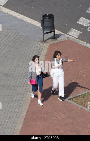 Eine junge Frau zeigt mit dem Finger irgendwo auf die Straße, während ihr Freund zusieht. Stockfoto