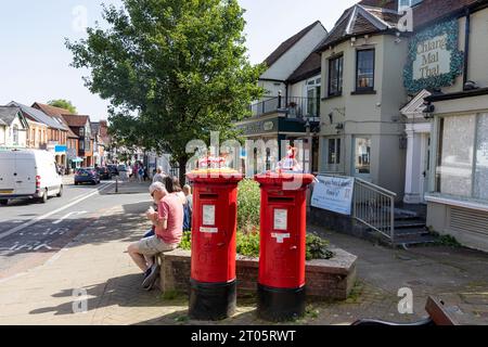Lyndhurst High Street und zwei rote Royal Mail Traditional Postboxen, Hampshire, England, UK Stockfoto