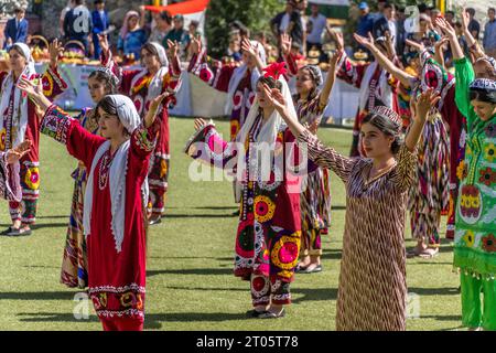Die tadschikischen Mädchen in bunten nationalen Outfits tanzen während des Tadschikistan Unabhängigkeitstages in der Provinz Gorno-Badakhshan. Stockfoto