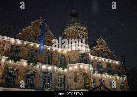 Spektakulärer Blick auf das Düsseldorfer Rathaus und den Weihnachtsmarkt mit schneebedecktem Weihnachtsbaum. Das Bild wurde bei leichtem Schneefall mit einem sensationellen Nachthimmel aufgenommen. Stockfoto