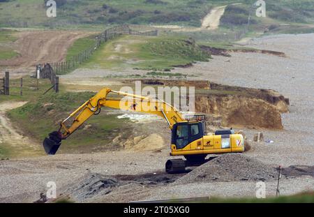 Bagger bei der Arbeit, der die Schindelmeer in Weybourne, Norfolk, Großbritannien baut. Mai Stockfoto
