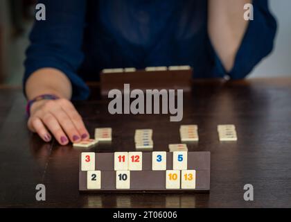 Zwei Spieler spielen ein beliebtes Brettspiel, rummikub-Fliesen auf dem Holztisch Stockfoto