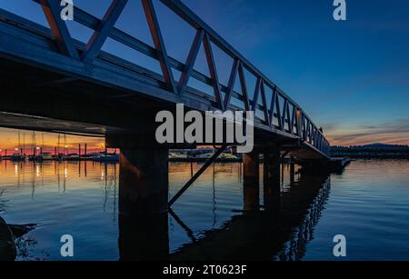 Holzsteg. Spaziergang am Bridge Pier bei Sonnenuntergang. Pier Bridge bei Nacht an der Westküste. Reisefoto, niemand Stockfoto