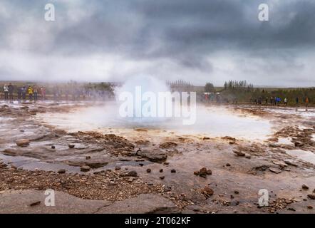 Island Geysir; Touristen, die Strokkur Geysir beobachten, der aufgrund geothermischer Energie ausbricht, auf der Golden Circle Tour, Strokkur, Island. Reisen Stockfoto