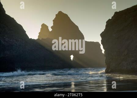 Fenster in Felsen am Meyers Creek Beach an der Pazifikküste im Pistol River State Park bei Sonnenuntergang, Oregon, USA Stockfoto