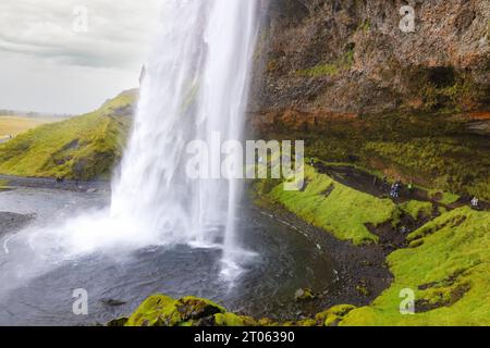 Island Wasserfall; Touristen, die hinter dem Seljalandsfoss Wasserfall auf der Golden Circle Tour spazieren; - island Tourismus, Reisen und Wasserfälle Stockfoto