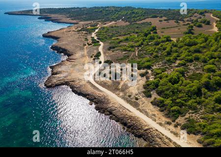 Aus der Vogelperspektive von der Drohne auf die felsige zerklüftete Küste mit einem Pfad an sonnigen Tagen, Cala Millor, Mallorca, Spanien, Balearen, Stockfoto
