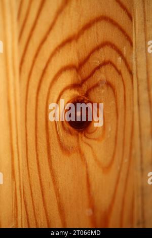Hölzerne fehlende braune Oberfläche Makro Schließen abstrakte Texturplatte aus Kiefernholz mit einem Ast Auge Knoten Loch Hintergrund brauner gelber hölzerner Stock Foto Stockfoto