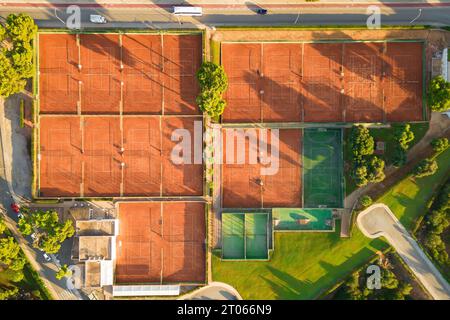 Aerial view from drone of empty tennis courts and football field during sunny morning Stockfoto