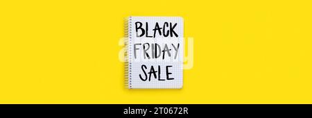 Black Friday Sale Schild auf offenem Notizbuch auf hellgelbem Hintergrund, Draufsicht-Banner, flaches Lay mit Kopierraum Panorama-Web-Header Stockfoto