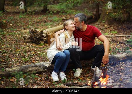 Reisenpaar zelten nach einem harten Tag über dem Feuer im Wald. Konzept für Trekking, Abenteuer und saisonalen Urlaub. Stockfoto