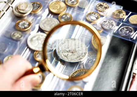 Sammeln von Münzen Numismatik. Album mit Lupe Stockfoto