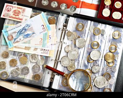 Münzen und venezolanische Bohlivars-Banknoten. Numismatik. Geld und Scheine mit Lupe Stockfoto