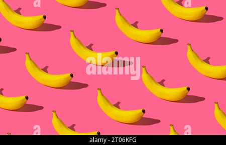Trendiges Fruchtmuster aus frischer Banane auf hellem pastellrosa Hintergrund. Minimales Layout mit Bananenmuster. Natur Sommer Hintergrund Konzept. Stockfoto