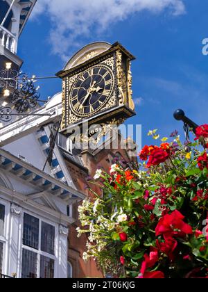 GUILDFORD HIGH STREET Guildhall Uhr aus dem Jahr 1683 mit saisonalen hängenden Blumenkorb Blumen im Vordergrund Guildford High Street Surrey UK Stockfoto