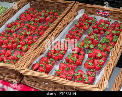 ERDBEEREN UNION JACK FLAGGE BRITISCHE KORBPUNNETS BAUERNMARKT frisch gepflückte, reife Erdbeeren, attraktive Anzeige in Punnets auf britischen Outdoor-Farm-Markt Stand UK Stockfoto