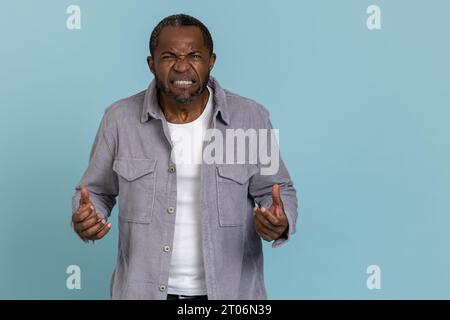 Ein wütender schwarzer Mann trägt graues Hemd geballte Fäuste Stockfoto