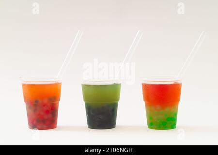 Kreatives Layout aus frischem und kaltem Bubble-Tee vor weißem Hintergrund. Trendige bunte Teekomposition. Minimale Idee für süße Getränke. Stockfoto