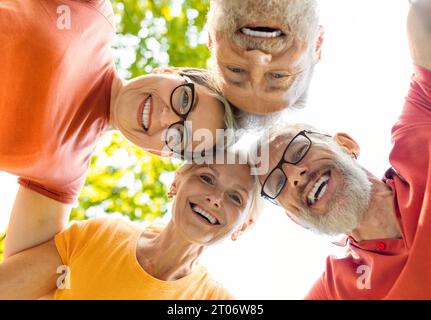 Gruppenporträt glücklicher Seniorenfreunde, die draußen auf die Kamera schauen Stockfoto