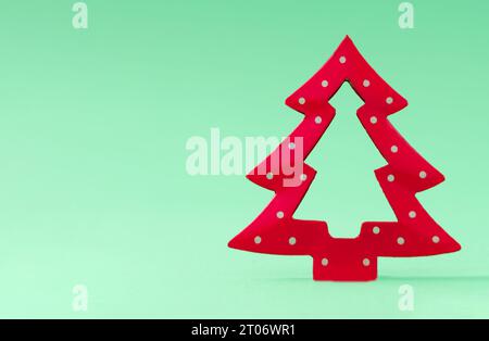 Minimalistischer Weihnachtsbaum auf pastellgrünem Hintergrund. Kreatives Weihnachts- oder Neujahrskonzept. Trendige Urlaubsidee mit Kopierraum. Stockfoto