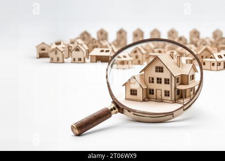 Der Immobilienentwickler plant, einem Agenten und einem Käufer das Miniaturlayout unter der Lupe zu zeigen Stockfoto