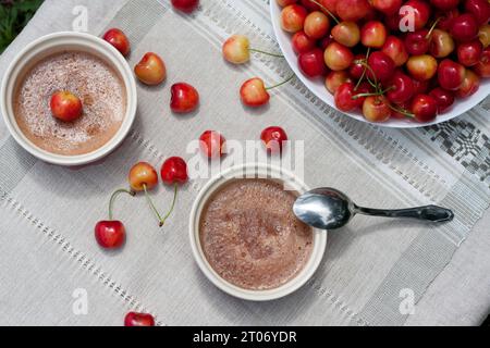 Hausgemachte Beerenmarmelade aus rosa Süßkirschen. Kühles Sommerdessert in portionierten Schüsseln auf dem Tisch und reife süße Kirschen. Köstliches und gesundes snac Stockfoto