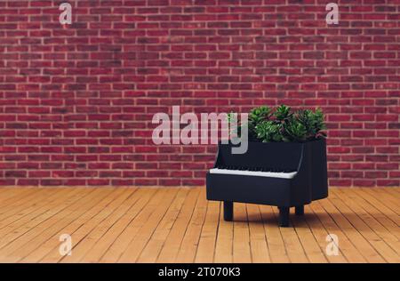 Kreative Komposition aus Klavier und grünen Blättern vor rotem Backsteinmauerhintergrund. Minimales Musikinstrumentkonzept. Trendiges Piano-Layout. Stockfoto