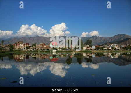 Oktober 2023, Srinagar Kashmir, Indien : Wohnhäuser spiegeln sich im Babdemb-See an einem sonnigen Tag in Srinagar. Am 04,2023. Oktober in Stockfoto