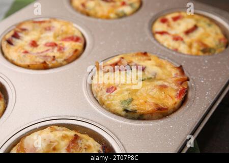 Frisch gebackener Speck und Eiermuffins mit Käse in der Dose, Nahaufnahme Stockfoto