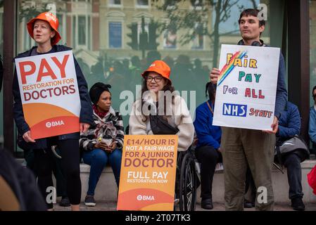 London, Großbritannien. Oktober 2023. Die Demonstranten halten Plakate, die ihre Meinung während des marsches vor dem Royal London Hospital zum Ausdruck bringen. Zum zweiten Mal fordern sowohl Berater als auch Juniorarzt Lohnerhöhungen und streiken landesweit zusammen in Großbritannien. The Unite die Gewerkschaft organisierte einen kurzen solidaritätsmarsch mit anderen Gewerkschaften wie BMA, PCS, UNISON, RMT für den letzten Streiktag rund um das Royal London Hospital in London, Großbritannien. Quelle: SOPA Images Limited/Alamy Live News Stockfoto