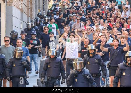 Feyenoord-Fans werden von der spanischen Nationalpolizei Stunden vor Beginn des Spiels gegen Atletico Madrid auf einer Straße im Zentrum Madrids begleitet. Fast 4.000 Ultras aus Feyenoord Rotterdam sind nach Madrid gereist, um die niederländische Mannschaft anzufeuern, die in der ersten Phase der UEFA Champions League im Stadion gegen Atletico de Madrid stand und in der der spanische Verein mit 3:2 gewann. Die Niederländer wurden immer von der spanischen Nationalpolizei begleitet. Fast 4.000 Ultras aus Feyenoord Rotterdam sind nach Madrid gereist, um die niederländische Mannschaft anzufeuern, die in t gegen Atletico de Madrid stand Stockfoto