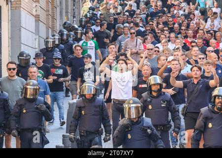 Feyenoord-Fans werden von der spanischen Nationalpolizei Stunden vor Beginn des Spiels gegen Atletico Madrid auf einer Straße im Zentrum Madrids begleitet. Fast 4.000 Ultras aus Feyenoord Rotterdam sind nach Madrid gereist, um die niederländische Mannschaft anzufeuern, die in der ersten Phase der UEFA Champions League im Stadion gegen Atletico de Madrid stand und in der der spanische Verein mit 3:2 gewann. Die Niederländer wurden immer von der spanischen Nationalpolizei begleitet. Fast 4.000 Ultras aus Feyenoord Rotterdam sind nach Madrid gereist, um die niederländische Mannschaft anzufeuern, die in t gegen Atletico de Madrid stand Stockfoto