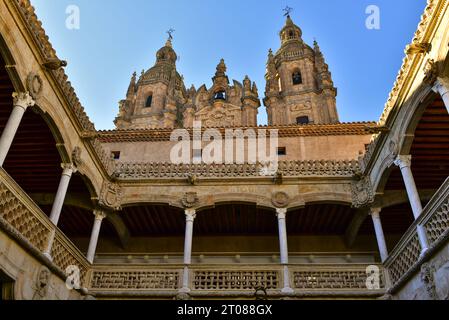 Der Innenhof des Shell House aus dem 15. Jahrhundert und die Türme von La Clerecía, einer barocken katholischen Kirche aus dem 18. Jahrhundert. Salamanca, Spanien, 18. Dezember Stockfoto