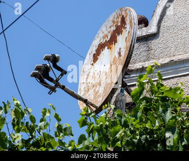 Satelliten-TV-Antenne an der Außenwand des Gebäudes auf einem Hintergrund des Himmels Stockfoto