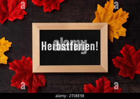 3. Oktober 2023: Tafel mit Inschrift Herbsturlaub mit bunten Blättern. Herbstferien für Kinder und Studenten FOTOMONTAGE *** Kreidetafel mit Aufschrift Herbstferien mit bunten Blättern. Ferien im Herbst für Kinder und Schüler FOTOMONTAGE Credit: Imago/Alamy Live News Stockfoto