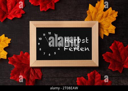 3. Oktober 2023: Tafel mit Inschrift Herbsturlaub mit bunten Blättern. Herbstferien für Kinder und Studenten FOTOMONTAGE *** Kreidetafel mit Aufschrift Herbstferien mit bunten Blättern. Ferien im Herbst für Kinder und Schüler FOTOMONTAGE Credit: Imago/Alamy Live News Stockfoto