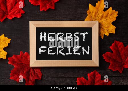 3. Oktober 2023: Tafel mit Inschrift Herbsturlaub mit bunten Blättern. Herbstferien für Kinder und Studenten FOTOMONTAGE *** Kreidetafel mit Aufschrift Herbstferien mit bunten Blättern. Ferien im Herbst für Kinder und Schüler FOTOMONTAGE Credit: Imago/Alamy Live News Stockfoto