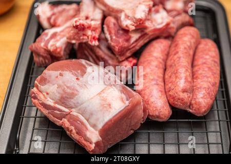 Zubereitung von Wurst, Rippchen, Rindfleisch, Zwiebeln und Tomaten für neapolitanische Ragù auf Orecchiette Pasta in der Hausküche Stockfoto