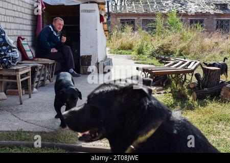 Orichhiv, Ukraine. Oktober 2023. Ein älterer Mann, der mit Hunden sitzt, neben dem Eingang des Tierhauses in Orichow. Die ukrainischen Streitkräfte setzen ihre Gegenoffensive in der Nähe von Orichschiw in der Region Zaporischja fort. Quelle: SOPA Images Limited/Alamy Live News Stockfoto