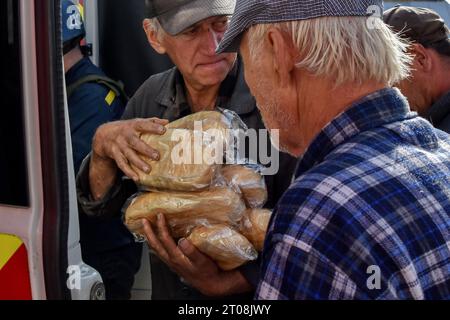 Orichhiv, Ukraine. Oktober 2023. Die Menschen erhalten Brotlaibe an einem Ort für humanitäre Hilfe in Orichschiv. Die ukrainischen Streitkräfte setzen ihre Gegenoffensive in der Nähe von Orichschiw in der Region Zaporischja fort. Quelle: SOPA Images Limited/Alamy Live News Stockfoto