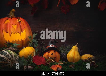 Halloween Hintergrund mit Kürbissen, Kastanien, Blättern und Halloween Dekoration vor der Holzwand Stockfoto